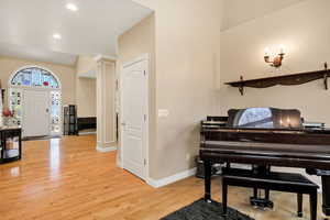 Foyer entrance featuring light wood-style floors, recessed lighting, and decorative columns