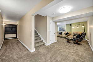 Living area featuring carpet flooring and stairway