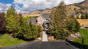 View of front of property featuring a front yard, a mountain view, and brick siding