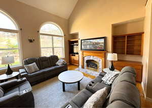 Living room with a fireplace and high vaulted ceiling