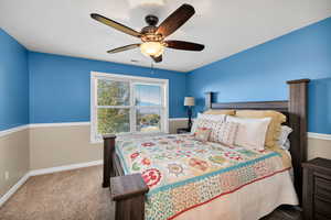 Bedroom with light carpet and a ceiling fan