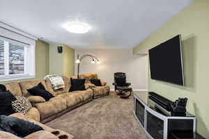 Living area with a textured ceiling and carpet flooring