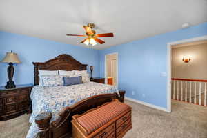 Carpeted bedroom featuring baseboards and a ceiling fan