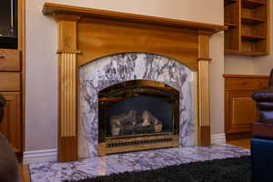 Detailed view of a tiled fireplace and baseboards in living room