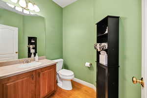 Half bathroom featuring vanity and light wood-type flooring