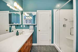 Primary Full bathroom featuring vanity, dark tile patterned floors, and a stall shower
