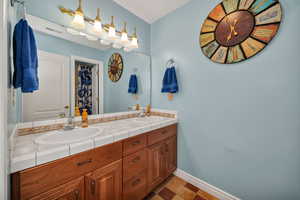 Bathroom with double vanity and curtained shower