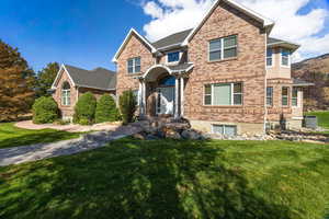 Traditional 2 story style home with brick exterior and a large front lawn