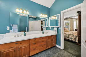 Primary Ensuite bathroom featuring double vanity, dark tile patterned flooring, and a shower stall