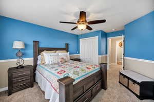 Bedroom featuring a closet, light carpet, and a ceiling fan