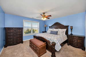 Bedroom with light colored carpet and ceiling fan