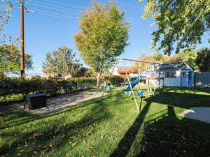 View of yard featuring a playground, a patio area, and an outdoor structure
