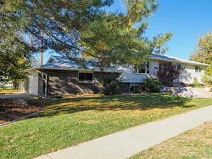 View of front of house featuring brick siding, a front lawn, and an attached garage