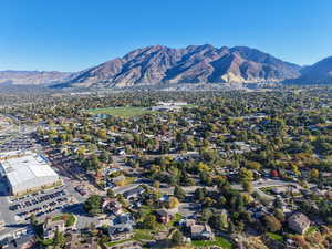 Aerial view of property and surrounding area with mountains and nearby suburban area