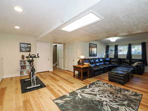 Living room featuring light wood-type flooring and a textured ceiling