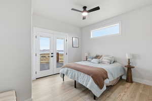 Bedroom with light wood-type flooring, access to outside, ceiling fan, and french doors