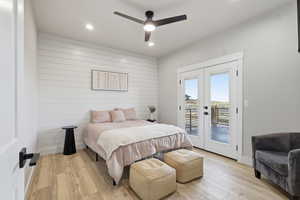 MASTER: Bedroom with french doors, wood finished floors, access to exterior, wood walls, and a ceiling fan
