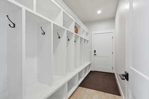 ENTRY BETWEEN GARAGE AND HOUSE: Mudroom featuring light wood finished floors and recessed lighting