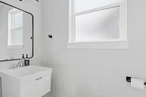 INSIDE GARAGE: Half bath with vanity and plenty of natural light