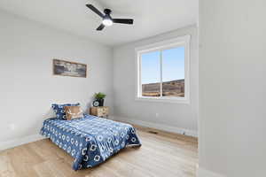 Bedroom with light wood-style floors and ceiling fan