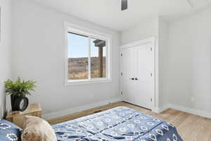 Bedroom featuring a closet, light wood-style flooring, and a ceiling fan
