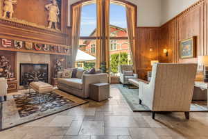 Living room with wood walls, a tile fireplace, and a high ceiling