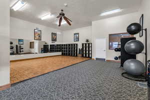 Workout room featuring a textured ceiling and ceiling fan