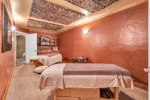 Bedroom with ornamental molding and a textured wall