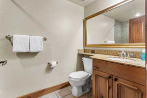 Full bathroom with light tile patterned flooring, vanity, a textured wall, and a shower with shower door