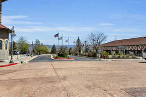 View of asphalt street featuring street lights, curbs, and sidewalks