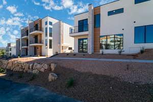 Rear view of property with stucco siding and a balcony