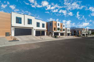 View of front of home with a residential view, stucco siding, an attached garage, driveway, and a mountain view