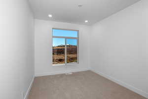 Empty room featuring light colored carpet and recessed lighting