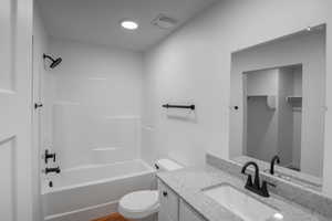 Bathroom with tub / shower combination, vanity, and LVT flooring