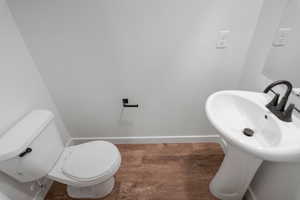 Half bathroom featuring black fixtures and LVT flooring