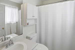 Full bath featuring vanity and curtained shower