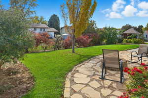 View of grassy yard with a patio area