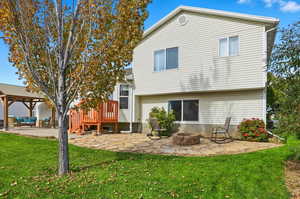 Rear view of house featuring a patio area, a lawn, and a fire pit