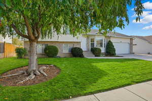 Tri-level home with brick siding, concrete driveway, and an attached garage