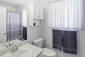 Full bath with curtained shower and vanity