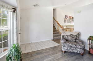 Living area featuring wood finished floors, stairway, and vaulted ceiling