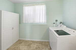 Laundry room featuring washer and clothes dryer and baseboards