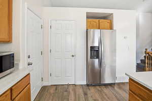 Kitchen featuring stainless steel appliances, dark wood finished floors, and brown cabinets