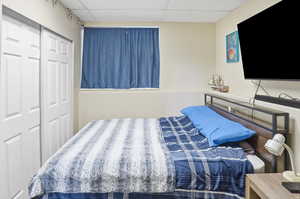 Bedroom featuring a drop ceiling and a closet