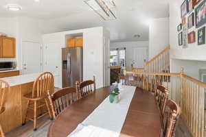 Dining area featuring light wood-style flooring and vaulted ceiling