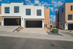 Modern home with stucco siding, concrete driveway, and an attached garage