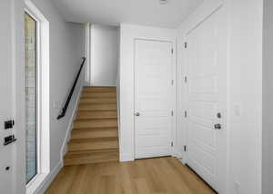 Staircase with wood finished floors and baseboards