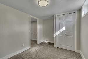 Unfurnished room with light carpet and a textured ceiling