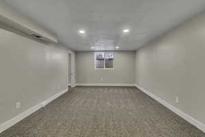 Below grade area featuring light colored carpet and recessed lighting