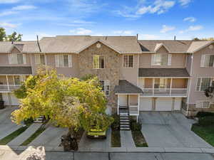 Traditional-style house featuring stone siding, concrete driveway, a shingled roof, and stairway
